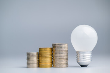 Small set of coins heaps with a small light bulb, starting the business idea, SMB, and SME, or savings concept