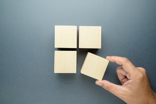 Closeup hand of a man pulling a piece of wood cube out of the group, a quarter needed concept, system implementation, market share or narrow target, and niche
