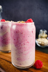Banana Raspberry Smoothies in Tumbler Glasses: Ombre pink smoothies with raspberries and granola garnish