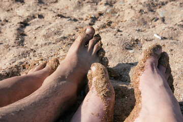 A gay couple is relaxing by the sea, sunbathing on the beach.