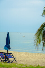 Beach bed ,canvas beds or trampoline with umbrellas in sea beach for tourists to rest on summer holiday with bright blue sky background at tropical island,Thailand.