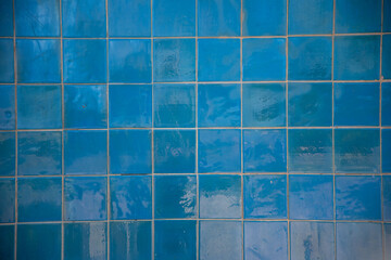 a blue tile wall with glossy reflection