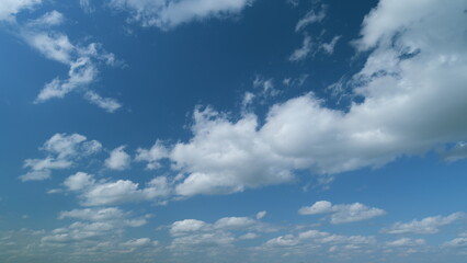 Beautiful sky background. Abstract look of natural white stratocumulus and cumulus clouds showing wind direction on blue sky. Timelapse.