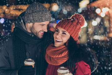 Photo of two funny people pair with hot beverage in hands spending x-mas evening together having...