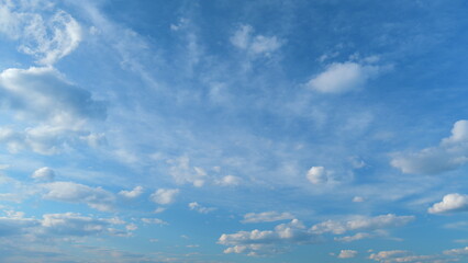Flying moving white clouds in a blue sky. Blue sky background with many layers tiny stratus cirrus clouds. Time lapse.