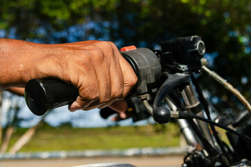Close-up of a hand on the handlebar of a three-wheeled motorcycle