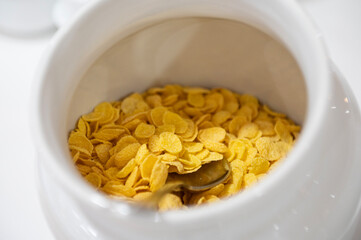 Close-up de un bol blanco lleno de cereales para desayuno. Copos de trigo. 