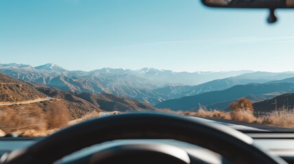 Scenic mountain view from inside a car driving along a winding road, showcasing nature and adventure.