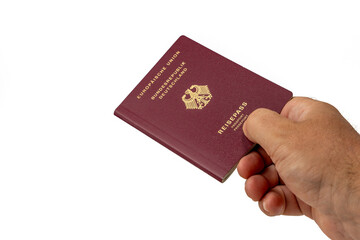 A hand holds a German citizen's passport on a white background. European passport close-up.