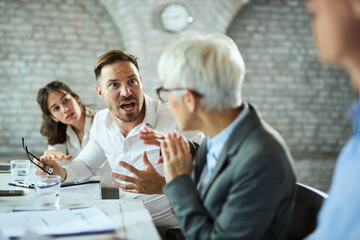 Angry entrepreneur screaming on his colleague during a meeting  in the office.