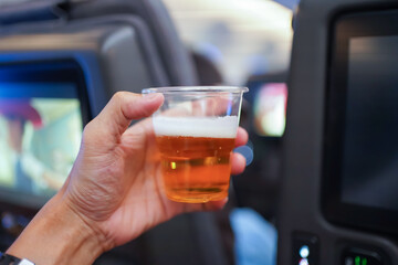 Hand holding  beer in aircraft