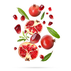 Fresh pomegranates, seeds and leaves in air on white background