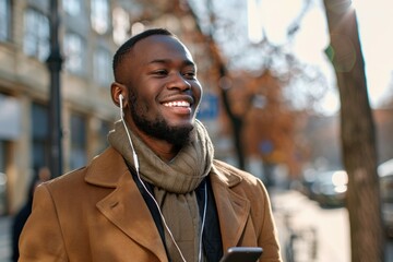 African American Listening To Phone. Happy man in earphones on street using mobile phone