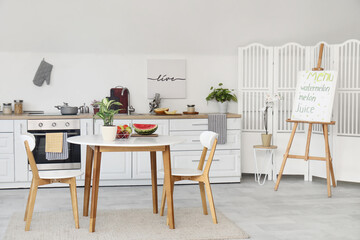 Interior of stylish modern kitchen with fresh melon and watermelon on table