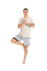 Young man doing yoga on white background