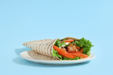 Plate with tasty doner kebab on blue background