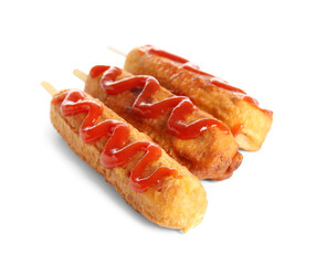 Tasty corn dogs with ketchup on white background