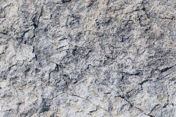 Stone cliff in the mountains, close-up. Natural stone background. Texture of cracks in stone.