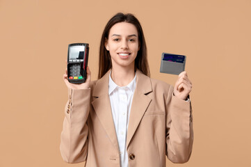 Beautiful woman with credit card holder and payment terminal on brown background