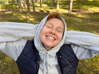 portrait of a cheerful girl in the forest enjoying the weather