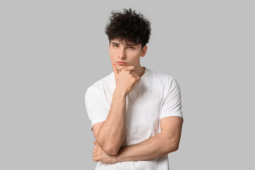 Young dark haired man on grey background