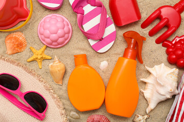 Beautiful composition with sunscreen and beach accessories for children on sand background