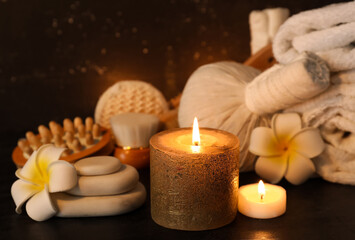 Beautiful spa composition with burning candles and tropical flowers on dark background
