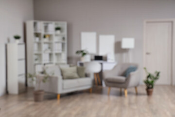 Blurred view of adolescent psychologist's office with sofa, armchair and plants