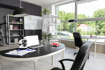 Interior of laboratory with desks, shelf units and whiteboard
