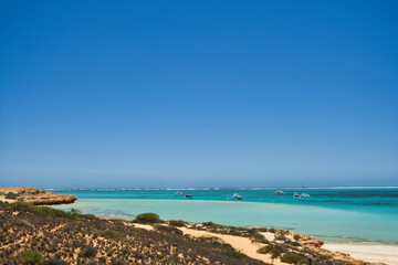 Shallow sea with pleasure craft and a sandy coast at Coral Bay, Ningaloo Coast, Western Australia
