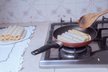 Preparation of pan fried tacos, frying Mexican tacos.