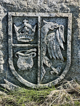A stone carving of the historic North Frisian coat of arms featuring a crown, a porridge pot, and a half eagle.