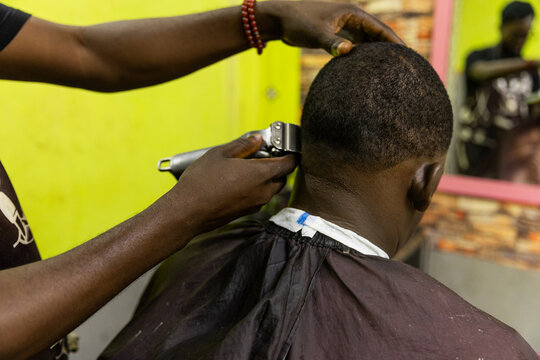 A man is getting his hair cut by a barber in Africa