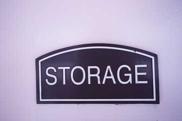 Fototapeta premium blue storage sign with white letters on a light colored wall, copy space available