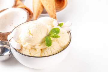 Vegan creamy coconut sorbet ice cream. Bowl with classic white coconut flavor non-dairy vegetarian gelato made with coconut milk, creamy frozen summer dessert