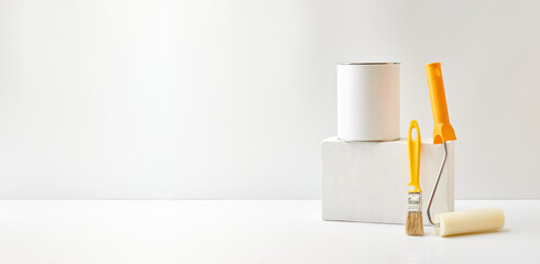 Geometric podium or pedestal with paint can, brush, sponge roller on a white background. Mock up...