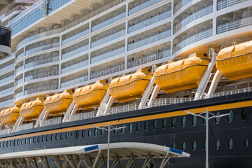 Yellow life safety boats in a row on a white cruise liner , Close up view.