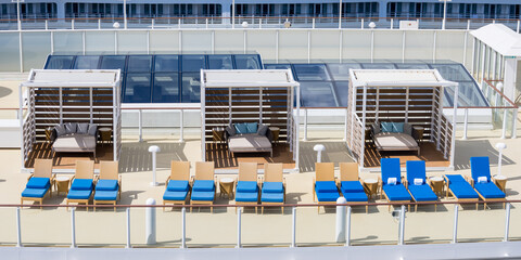 Aerial view of Cabanas and beach chairs on a cruise liner deck.
