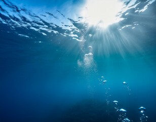 Bubbles underwater view from under the deep dark blue ocean with sunlight rays 