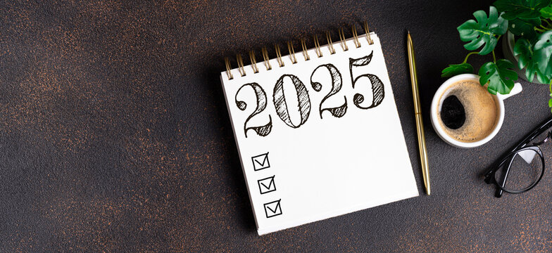 New year resolutions 2025 on desk. 2025 resolutions list with notebook, coffee cup on table. Goals, resolutions, plan, action, checklist concept. New Year 2025 template, copy space