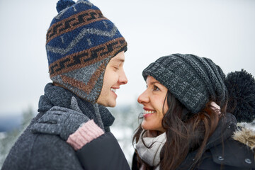 Winter, snow and love of couple with embrace, affection and bonding together in relationship with hug. Outdoor, man and woman in marriage for vacation, adventure and holiday for backpacker in Canada