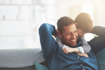 Father, boy and hug for laughing on sofa together in home, bonding and funny conversation. Daddy, son and happy family playing in living room for joke, talk and embrace for security in relationship