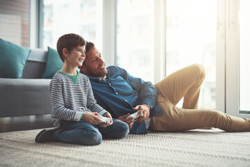 Man, video game and kid with smile on floor for entertainment, care or fun competition together. Family, father and son with controller in living room for support, love or learning of esports at home