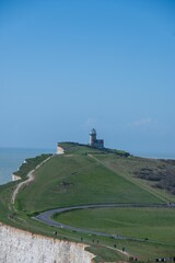 Scenic view of the Belle Tout Lighthouse on the cliffs of Beachy Head with a clear blue sky.