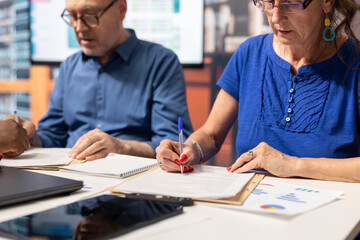 Senior couple signing the contract for a pension plan in a meeting with banker, agreeing on the perfect retirement option package to benefit from, financial stability and security.