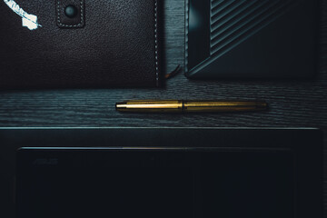 Workplace. Notebook with pen and tablet on a wooden table. Strict style