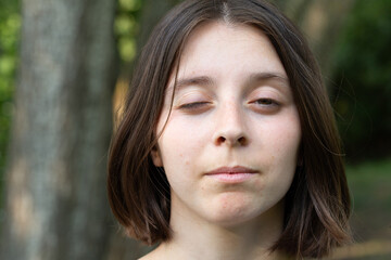 Young woman winking one eye outdoors portrait