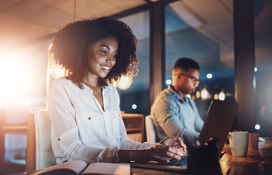 Laptop, night and business woman in office with research for wealth management report with deadline. Computer, typing and African female actuary working overtime on financial investment analysis.
