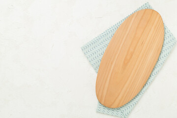 Cutting board with napkin on concrete background, top view
