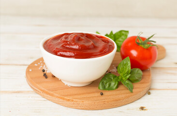Delicious ketchup with spices and tomatoes on wooden table